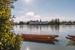 two boats sitting in the water in front of a building at Marga`s Ferienwohnung in Lembach im Mühlkreis