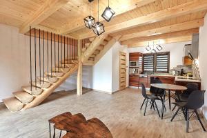 a living room with a staircase and a table and chairs at Domek Apartament u Wilków na wyłączność Zakopane in Zakopane