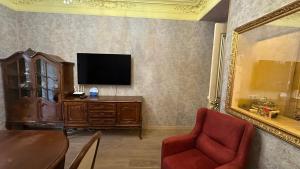 een woonkamer met een televisie en een tafel en stoelen bij Downtown Luxury furnished apartment in Jerevan