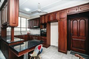a kitchen with wooden cabinets and a black counter top at Asian Residencies - Grandpass in New Bazaar