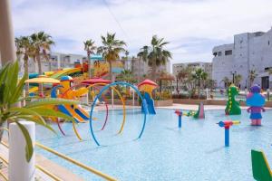 a pool with a water park with a water slide at Excellent appartement S+2 au PALM lake resort in Monastir