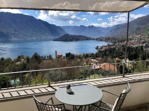 einen Tisch und Stühle auf einem Balkon mit Seeblick in der Unterkunft Alveluu ristorante e suites in Tremezzo