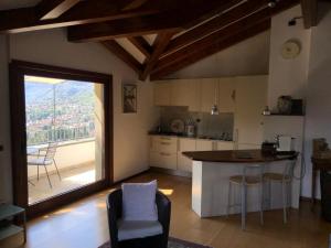 eine Küche mit einem großen Fenster sowie einem Tisch und Stühlen in der Unterkunft Alveluu ristorante e suites in Tremezzo