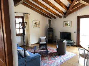 ein Wohnzimmer mit einem blauen Sofa und einem TV in der Unterkunft Alveluu ristorante e suites in Tremezzo