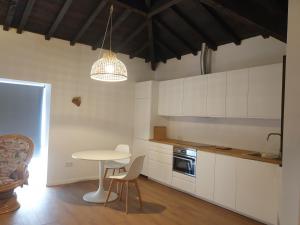 una cucina con armadi bianchi e tavolo con sedie di Quinta de Sobre a Fonte Charming Apartments a Fontelas