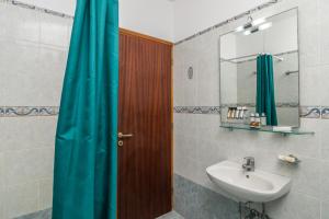 a bathroom with a sink and a wooden door at Olive Studios in Adamantas +32 photos