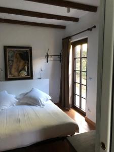 a bedroom with a large white bed and a window at Alveluu ristorante e suites in Tremezzo