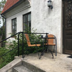 zwei Stühle auf einem Geländer neben einer Tür in der Unterkunft Nickarve Gård Hejdeby in Visby