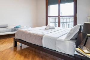 a large bed in a room with a large window at Broletto Park Apartment - Affitti Brevi Italia in Lecco