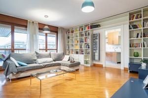 a living room with a couch and book shelves at Broletto Park Apartment - Affitti Brevi Italia in Lecco
