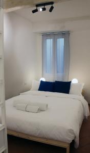 a large white bed with blue pillows and a window at Friends of Michelangelo in Florence