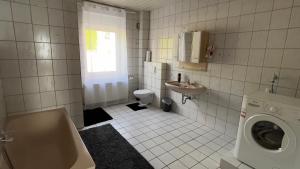 ein Badezimmer mit einer Waschmaschine und einem Waschbecken in der Unterkunft Pension Reiter in Blomberg