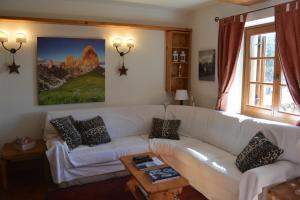 sala de estar con sofá blanco y mesa en Villa Ronco - Stayincortina, en Cortina dʼAmpezzo