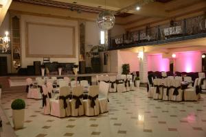 un salón de banquetes con sillas blancas y una pantalla de proyección en ILLARA SPA Hotel en Irshava