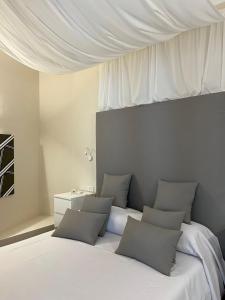 - une chambre avec un grand lit blanc et des oreillers dans l'établissement Relais Piazza Del Popolo, à Rome