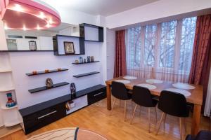 a dining room with a table and black chairs at Cozy Apartment in Suceava in Suceava