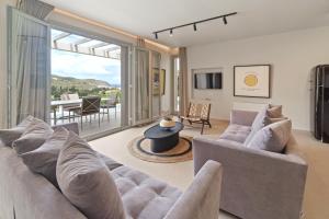 a living room with a couch and chairs and a table at Suite Home Villas with Private Pools by Explore Andros in Andros