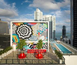 a mural on the side of a building with a pool at citizenM Miami Brickell in Miami