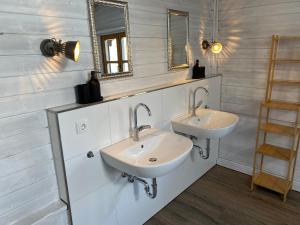 ein Badezimmer mit zwei Waschbecken und zwei Spiegeln in der Unterkunft Holzhaus auf 2000qm in traumhafter Lage, KEINE Partygruppen in Schalkenbach