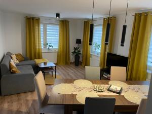 a living room with a couch and a dining room table at Apartament MONABERG in Łomnica