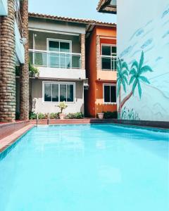 a swimming pool in front of a house at Hotel Dunas Village Cumbuco in Cumbuco