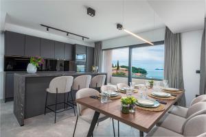 comedor y cocina con mesa y sillas en "Villa AnMari" The Cavtat View Residence, en Cavtat