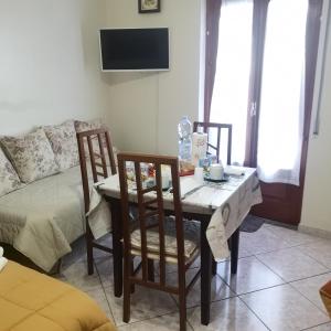 ein Wohnzimmer mit einem Tisch, Stühlen und einem Sofa in der Unterkunft Antico Portale - Host Roberto in Regalbuto