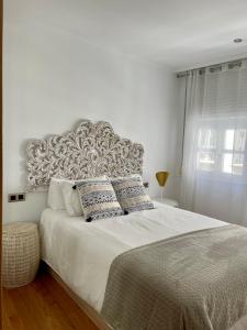 - une chambre blanche avec un grand lit et des oreillers dans l'établissement A Das Marias GALLERY, à Ourense