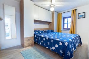 una camera da letto con un letto blu con stelle bianche sopra di Holiday House Nova a Stara Baška