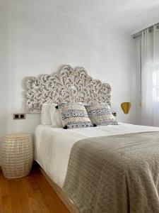 - une chambre avec un grand lit et une grande tête de lit dans l'établissement A Das Marias GALLERY, à Ourense