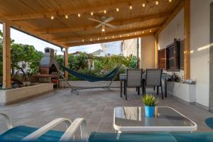 a patio with a hammock and a table and chairs at Holiday House Nova in Stara Baška