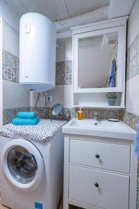 a bathroom with a washing machine and a sink at Holiday House Nova in Stara Baška