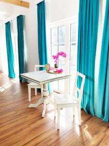una mesa blanca y sillas en una habitación con cortinas azules en Royal Horses en Overijse