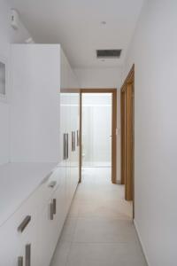 - un couloir d'une salle de bains avec des murs blancs et des miroirs dans l'établissement Parikia's Cosy Jewel, à Parikia