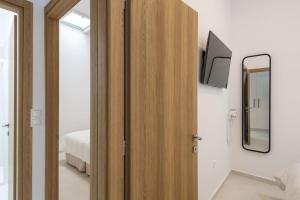 パリキアにあるParikia's Cosy Jewelの壁にテレビが取り付けられた寝室の木製のドア