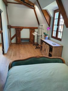a bedroom with a bed and a desk and windows at Entre Galets in Sauveterre