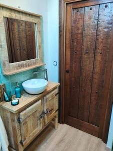 a bathroom with a sink and a wooden door at Entre Galets in Sauveterre