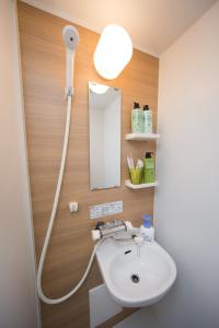 a bathroom with a white sink and a mirror at Ebisu Ryokan in Kyoto