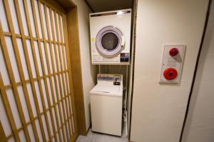 un piccolo bagno con lavatrice e lavatrice di Ebisu Ryokan a Kyoto