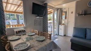 een woonkamer met een eettafel en een televisie bij Mobilhome Eleganzia 713 Bonne Anse Plage in Les Mathes