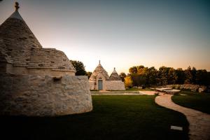 a stone building with the sun setting in the background at Borgo Del Tempo Ritrovato - Luxury Relais in Puglia in Ostuni