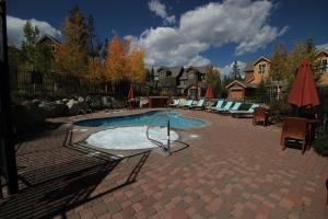 einen Pool im Garten mit Stühlen und Sonnenschirmen in der Unterkunft Settlers Creek 6514 in Keystone
