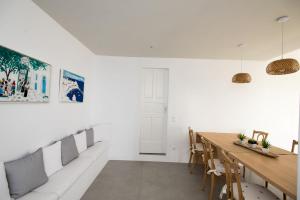 una sala da pranzo con pareti bianche e tavolo in legno di Mykonos Serendipity Villas a Platis Yalos