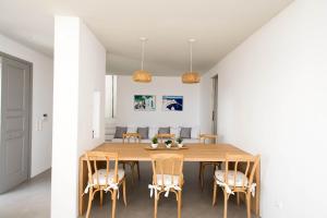 una sala da pranzo con tavolo e sedie in legno di Mykonos Serendipity Villas a Platis Yalos