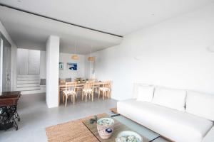 un soggiorno con divano e tavolo di Mykonos Serendipity Villas a Platis Yalos