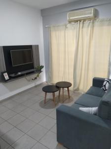 uma sala de estar com um sofá e uma televisão em Dpto CERCANIA em San Fernando