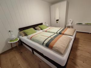 sypialnia z dużym łóżkiem z zielonymi poduszkami w obiekcie Ferienwohnung 'Unter der Burg' w mieście Brodenbach