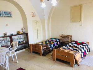 a room with two beds and a table and chairs at Traditional House with Amazing Veranda in Bethlehem