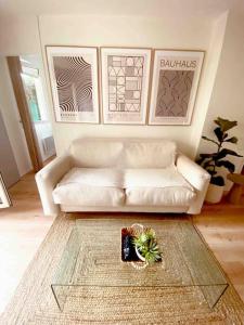 uma sala de estar com um sofá branco e uma mesa em Le Ludz Blagnac em Blagnac