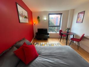 a bedroom with red walls and a bed and a table at Iconic City Centre Apartment in the Devonshire Quarter in Sheffield